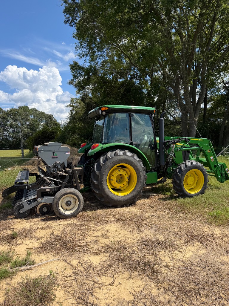 John Deere tractor fitted with a grain drill and front loader