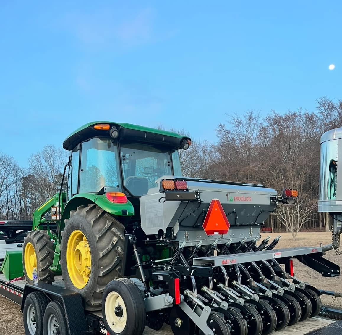 Tractor with seed drill loaded on a trailer